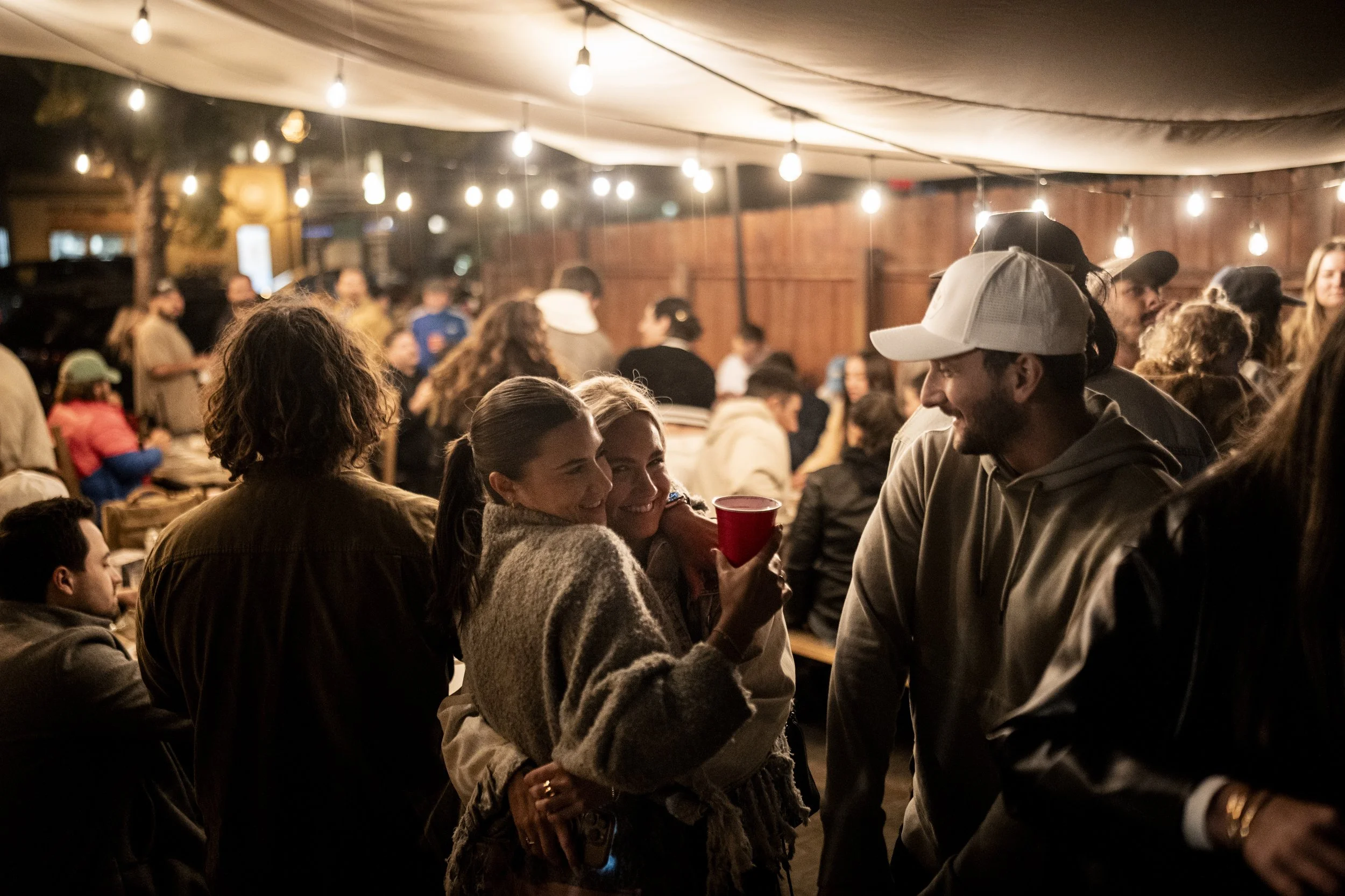 A warm crowd under string lights